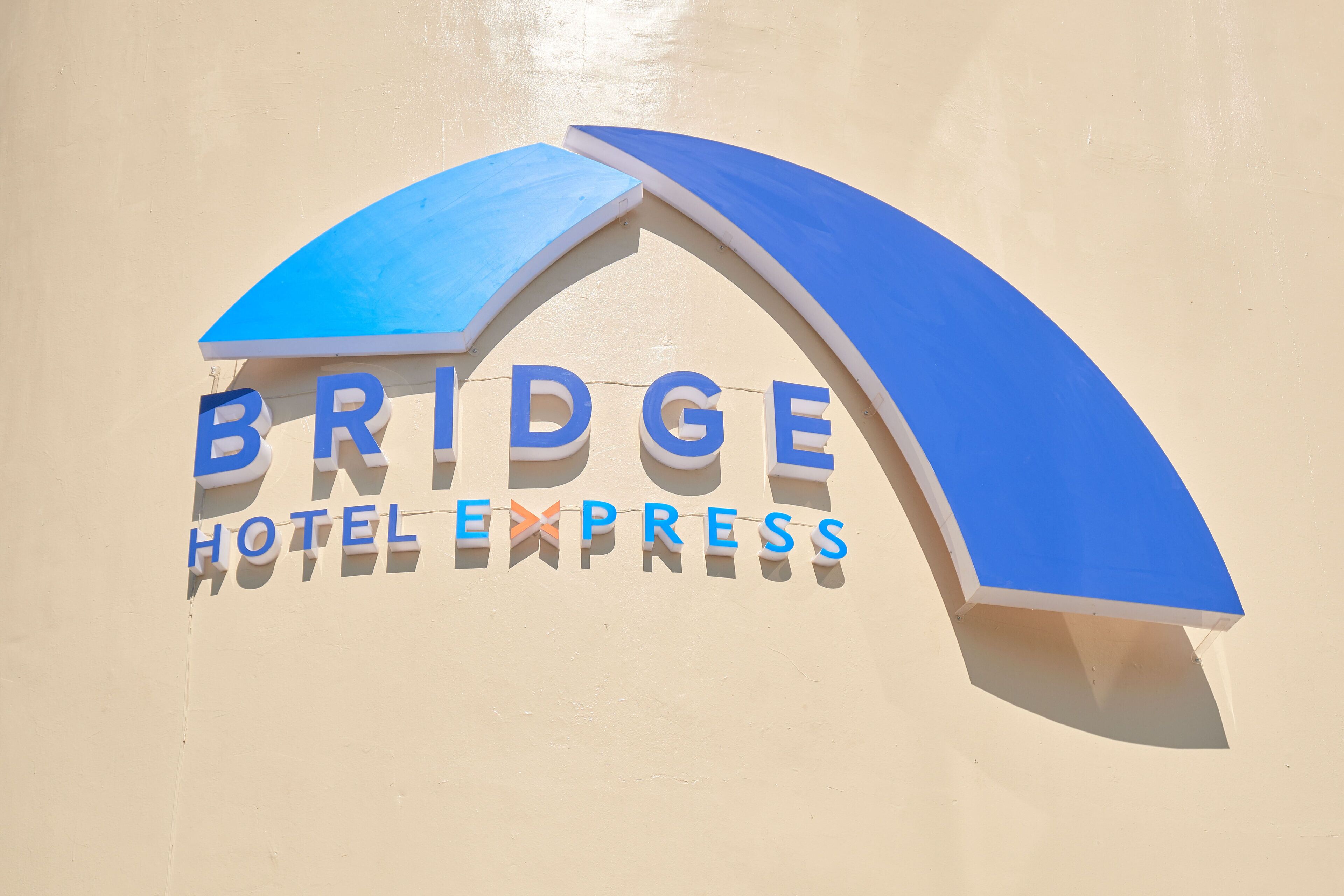 Une enseigne pour l’hôtel Bridge Hotel Express, avec un arc bleu.