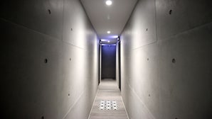 A narrow, well-lit hallway with a patterned floor, leading to a door at the end. - Hama Star (Kaohsiung)