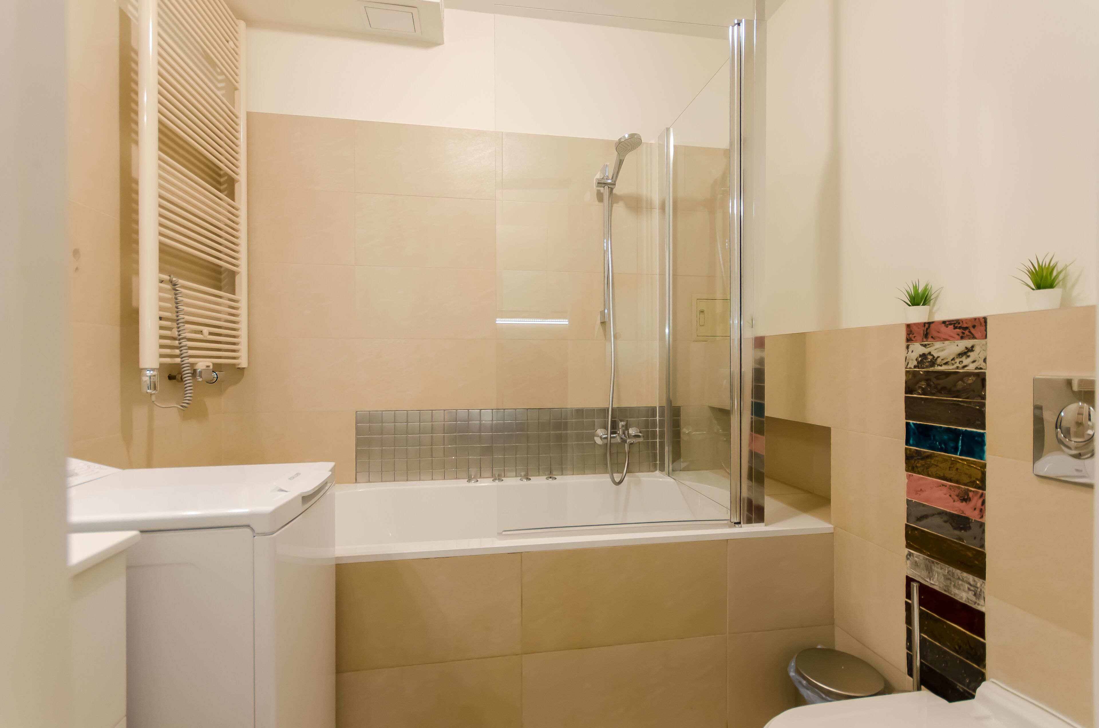 Une salle de bain moderne avec une douche à parois de verre, une baignoire blanche et des toilettes.