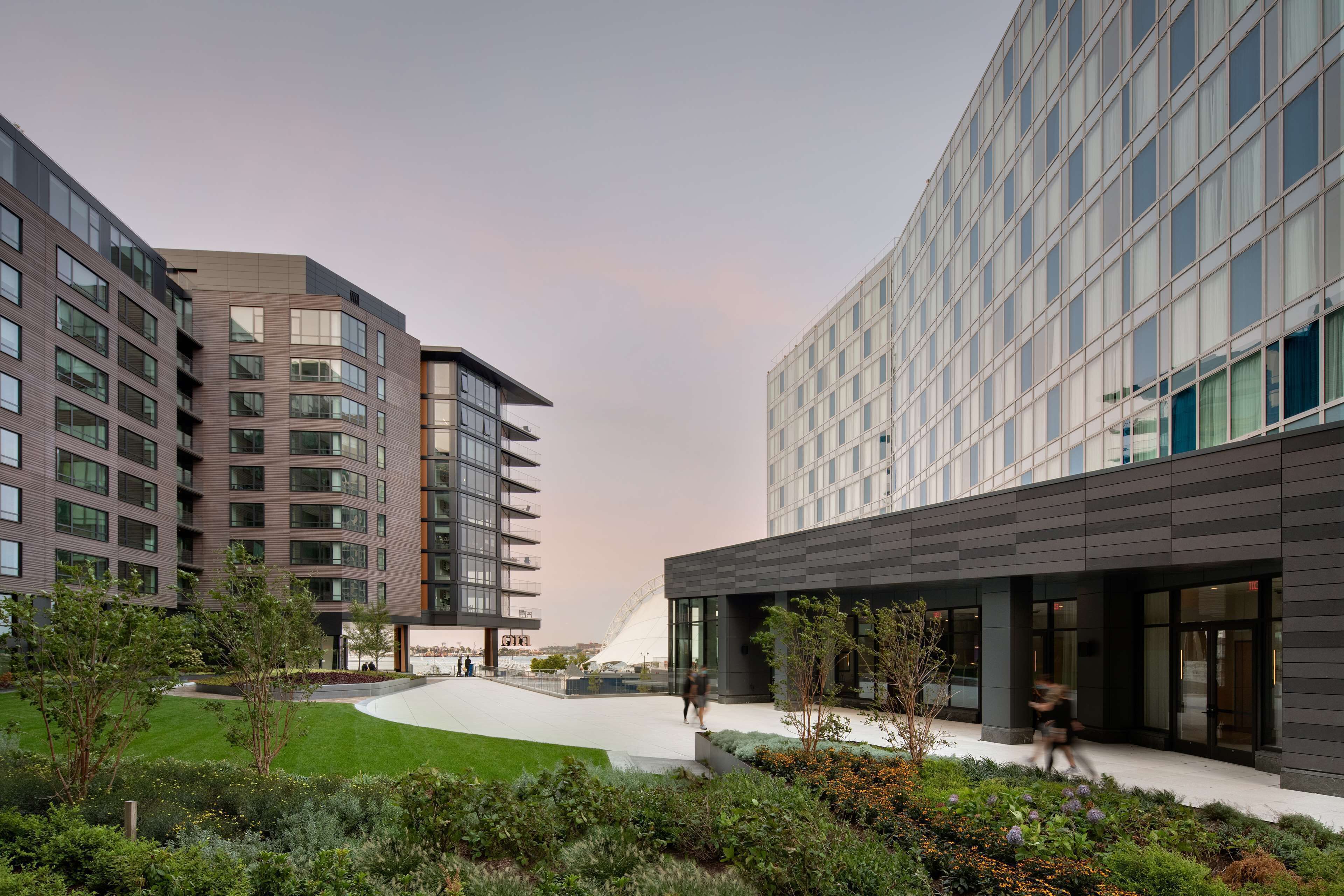 A modern building with multiple floors, large windows, and a landscaped courtyard.