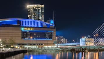 Un estadio grande con un letrero destacado que dice 'Garden', un puente al fondo y un entorno junto al agua.