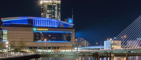 Un estadio grande con un letrero destacado que dice 'Garden', un puente al fondo y un entorno junto al agua.