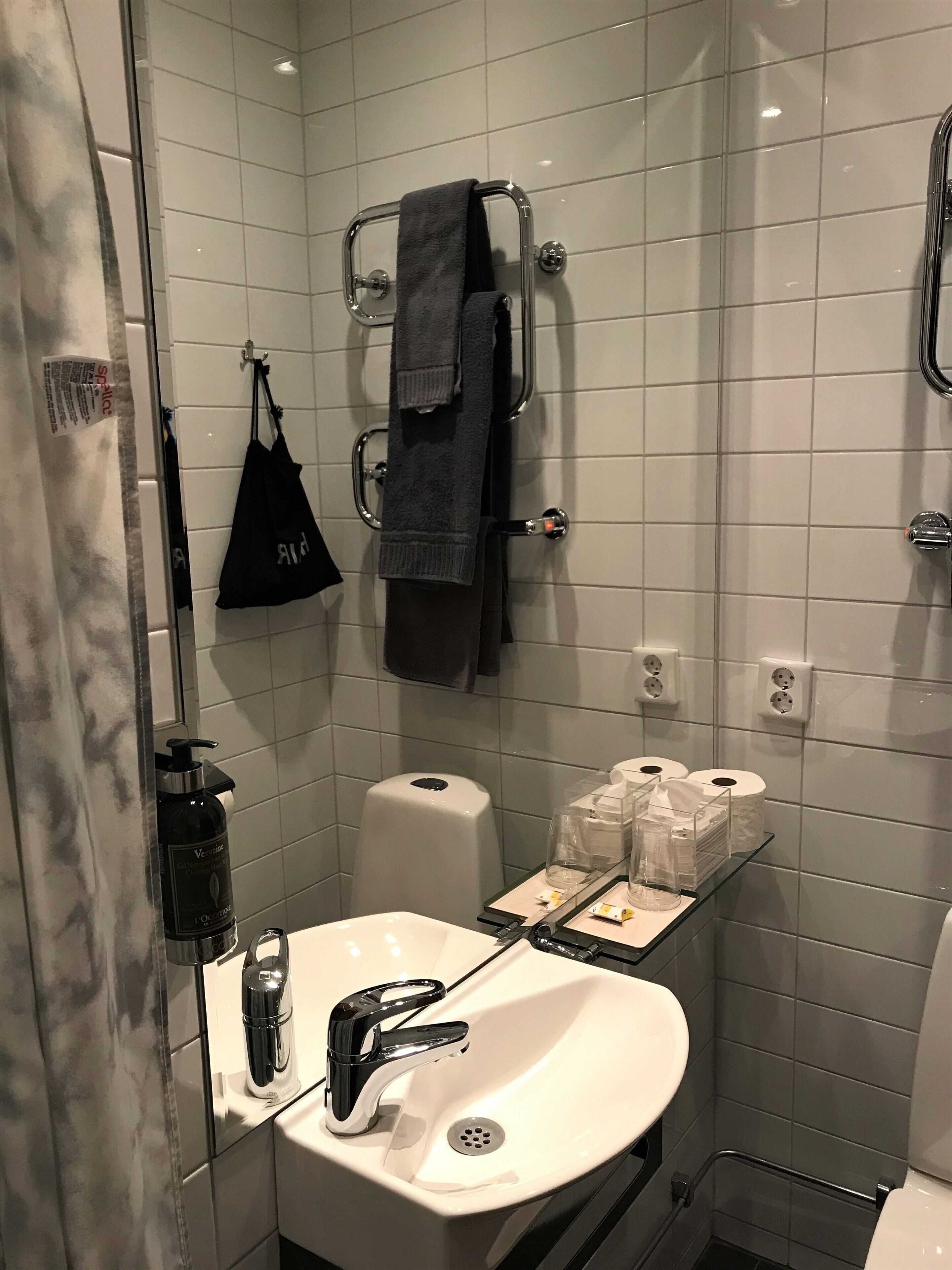 Un baño moderno con lavabo blanco, grifo cromado y cabina de ducha de vidrio.