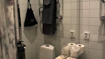 Un baño moderno con lavabo blanco, grifo cromado y cabina de ducha de vidrio.