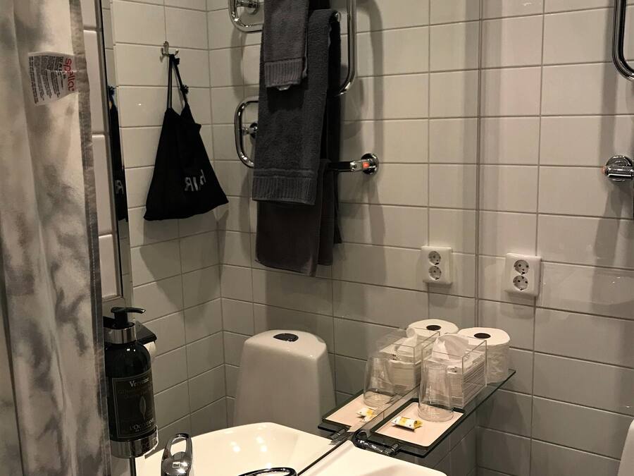 Un baño moderno con lavabo blanco, grifo cromado y cabina de ducha de vidrio.