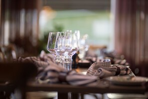 Une table à manger avec plusieurs verres à vin et des serviettes soigneusement pliées.