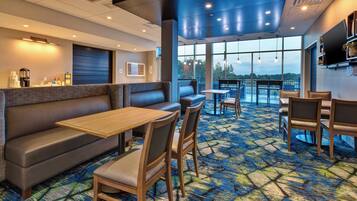 Comedor de hotel con asientos tipo cabina, un bar y vistas al exterior.