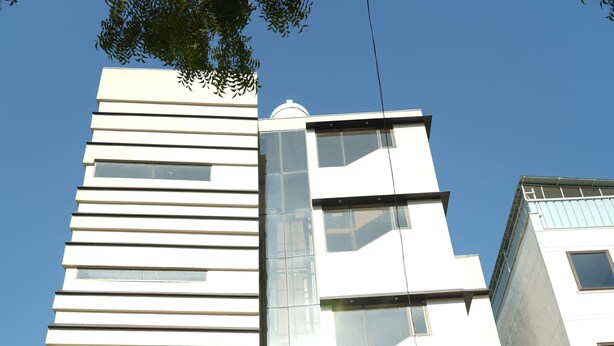Entrada de un hotel con un cartel que dice "The Bayan Elegance" y una fachada de edificio moderna.