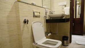 Un baño con inodoro, lavamanos y espejo.