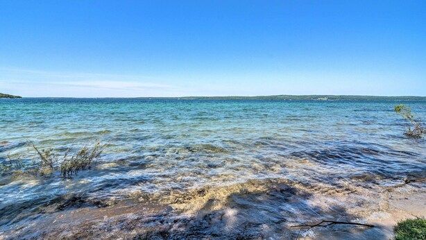 Una vista despejada de una playa con aguas tranquilas y tierra a lo lejos.