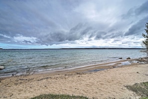 Experience the tranquility of a secluded beach with calm waters and a wide sandy shore.