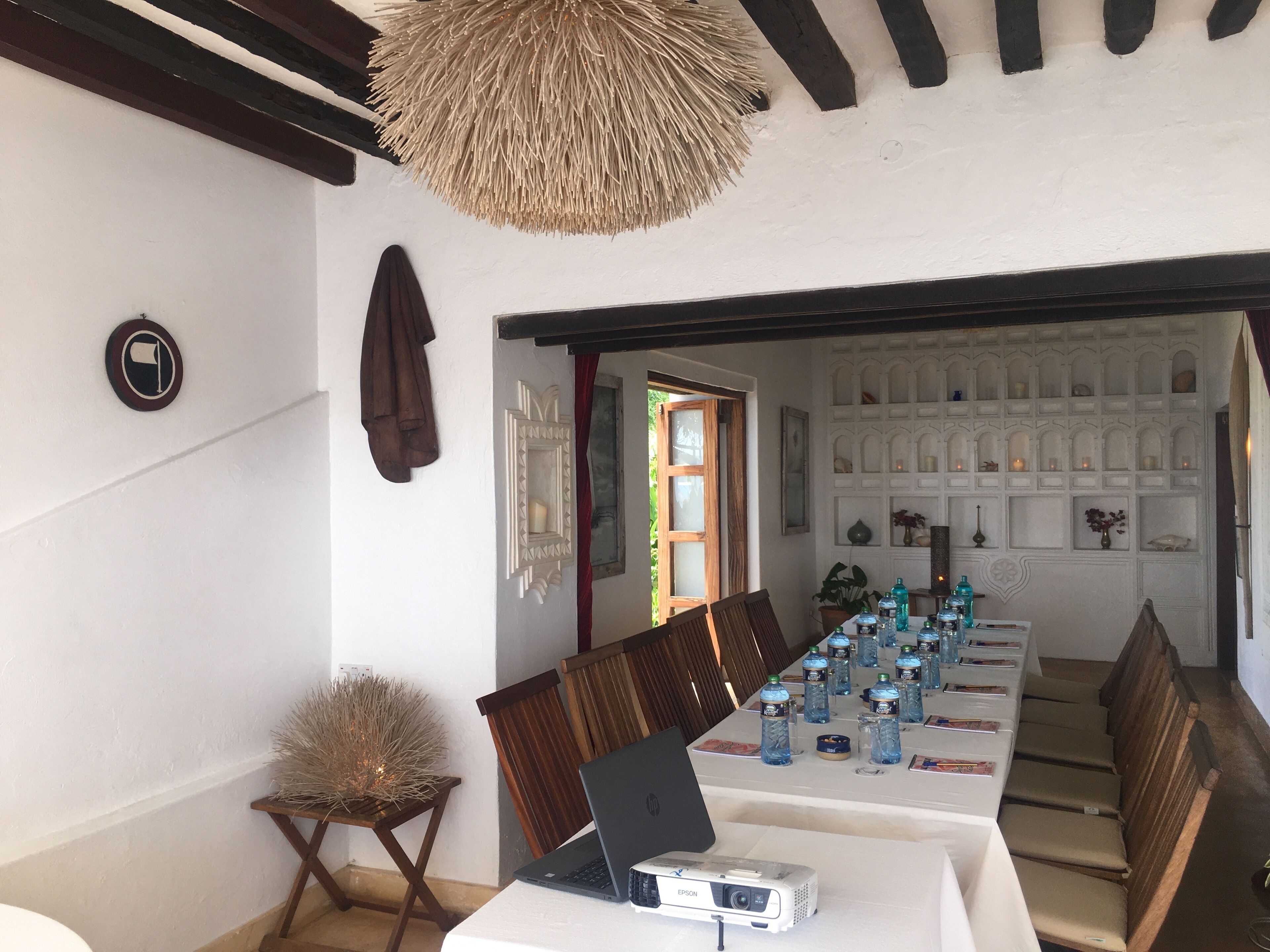 Una sala de conferències amb una taula llarga, cadires, un ordinador portàtil i un projecte.