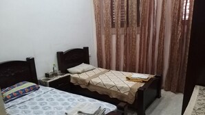 Ein kleines Schlafzimmer mit zwei Einzelbetten, einem Nachttisch und einem Tisch mit Tischdecke.