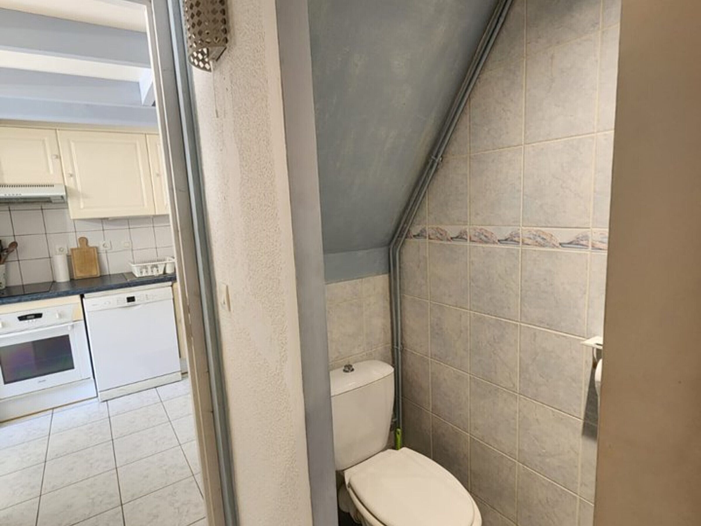 Un baño con inodoro, zona de ducha y lavamanos.