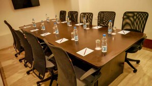 Ein Konferenzraum mit einem langen Tisch, Stühlen, Wasserflaschen und Namensschildern.