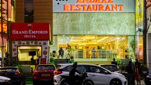 Ein Gebäude mit einem Restaurant namens "ANDAAZ RESTAURANT" und einem Hotel namens "GRAND EMPORIO HOTEL" im Erdgeschoss.