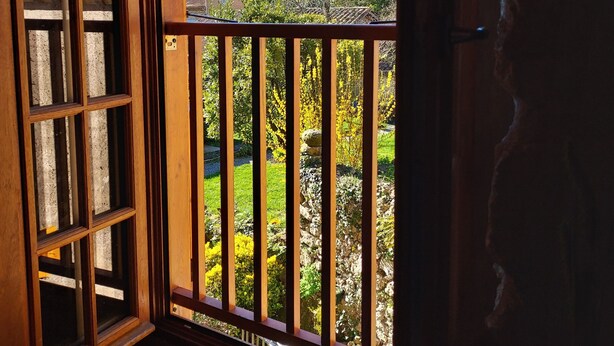 A room with a wooden balcony overlooking a mountainous landscape. - La Cousteto accommodation in a 17th century fortified house (Roquefixade)