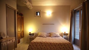 A bedroom with a bed, bedside tables, a dresser, a wardrobe, and a small window. - Le Pigeonnier de Guerre (L'Isle-Jourdain)