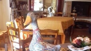 A dining table with a decorative ceramic goose centerpiece, a coffee pot, and a plate of pastries. - Le Pigeonnier de Guerre (L'Isle-Jourdain)