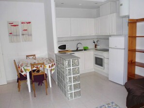 Een koelkast, kookgerei, borden en bestek