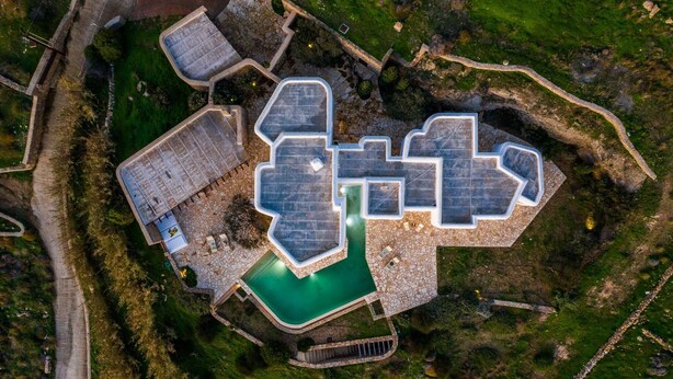 An aerial view of a resort with a swimming pool, multiple guest rooms, and a stone pathway. - Zen Residence in Lia beach (Mykonos)
