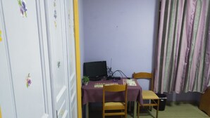 A small room with a desk, chair, and a computer. There is a door with a floral decoration and a curtain on the right side. - Pinguino Hostel Athens (Athens)