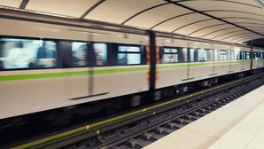 A train in a station with a curved roof structure. - Pinguino Hostel Athens (Athens)