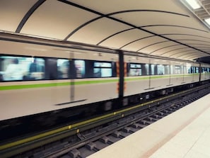 A train in a station with a curved roof structure. - Pinguino Hostel Athens (Athens)