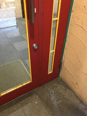 Une porte rouge avec un cadre jaune et une poignée en métal.