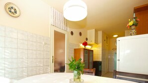 A kitchen with a dining table, a refrigerator, and a cabinet. - Apartment 1995/28135 (Istria - Pula), 750m from the beach (Pula)