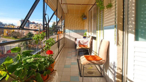 A balcony with potted plants, a chair, and a table. - Apartment 1995/28135 (Istria - Pula), 750m from the beach (Pula)