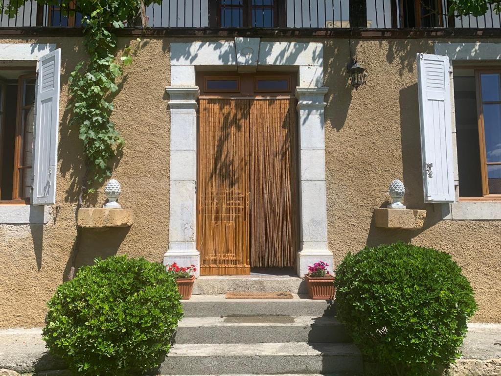 A building with a wooden door, white shutters, and a stone facade.