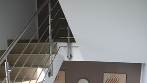 Una escalera moderna con barandillas de metal y peldaños color beige.