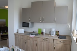 A compact kitchen with a microwave, toaster, and coffee maker.