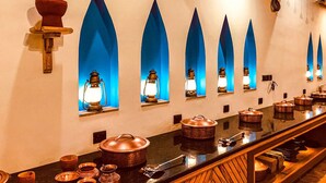 A long counter with multiple tea pots and a variety of tea cups. - Arch The Baakhli Resort (Ramnagar)