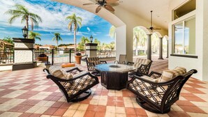 A covered outdoor patio with a checkered floor, wicker furniture, and a central table. - Aco7947ha - Bella Vida Resort - 4 Bed 3 Baths Townhome (Kissimmee)