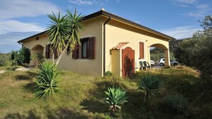 A single-story building with a yellow facade, wooden shutters, and a tiled roof. - Armandiola 3 apartment (Cardedu)