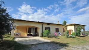 A two-story house with a covered patio, a small garden, and two lounge chairs. - Armandiola 3 apartment (Cardedu)
