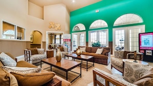 A spacious living area with a high ceiling, large windows, and a green accent wall. - Aco7946ha - Bella Vida Resort - 6 Bed 5 Baths House (Kissimmee)