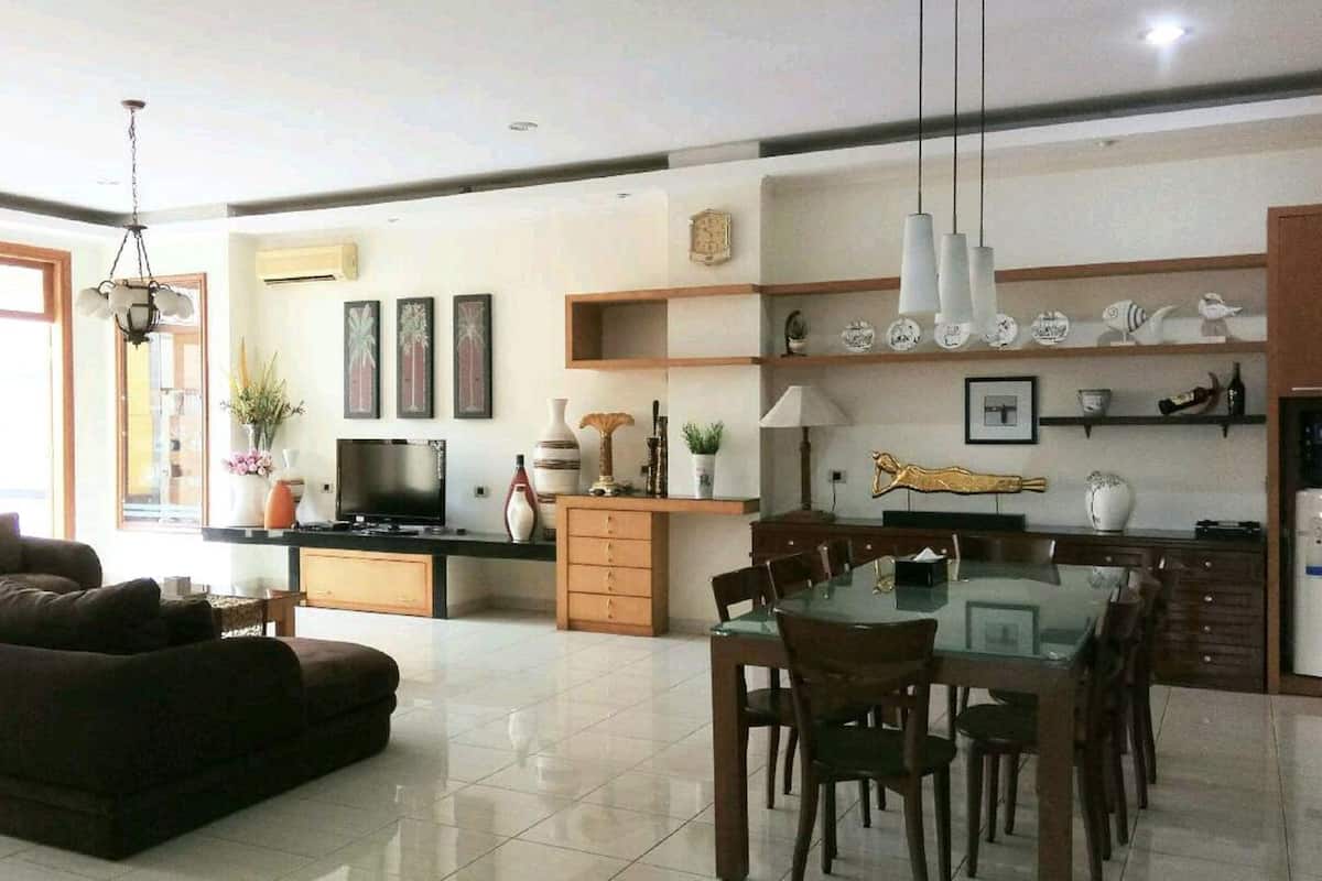 Una cocina moderna con comedor, sofá y televisor.