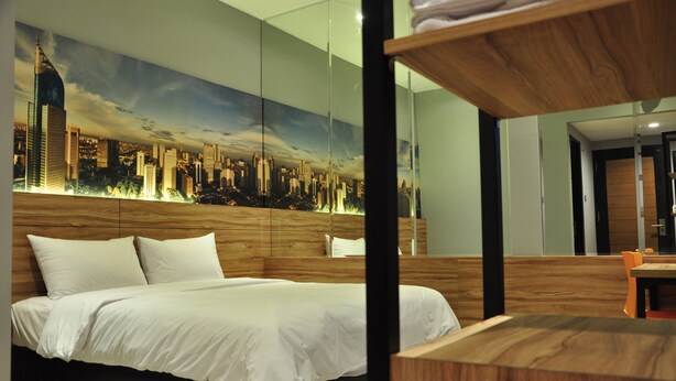 Una habitación de hotel moderna con una cama grande, un cabecero de madera y un mural con vista a la ciudad.