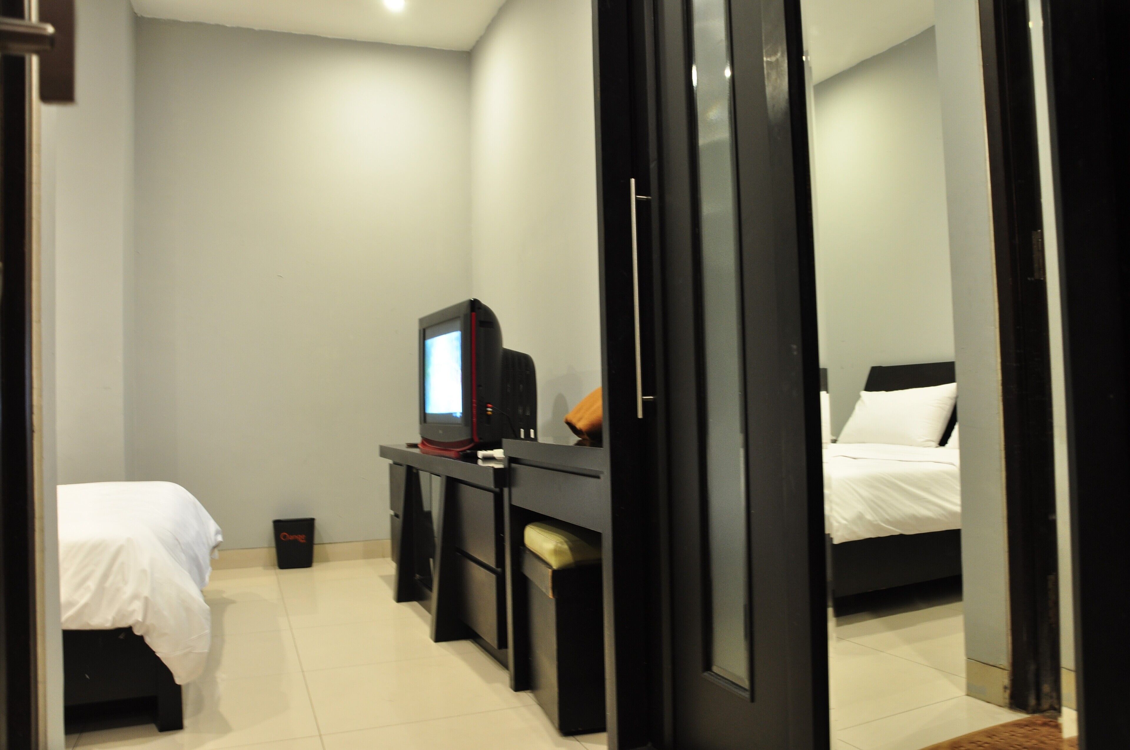 Ein Hotelzimmer mit einem Bett, einem Schreibtisch mit Computer und einem Fernseher.