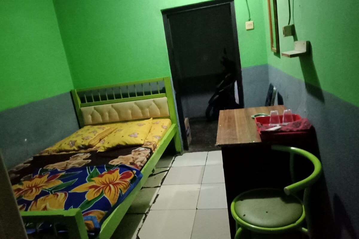 A small room with a bed, a desk, and a chair.