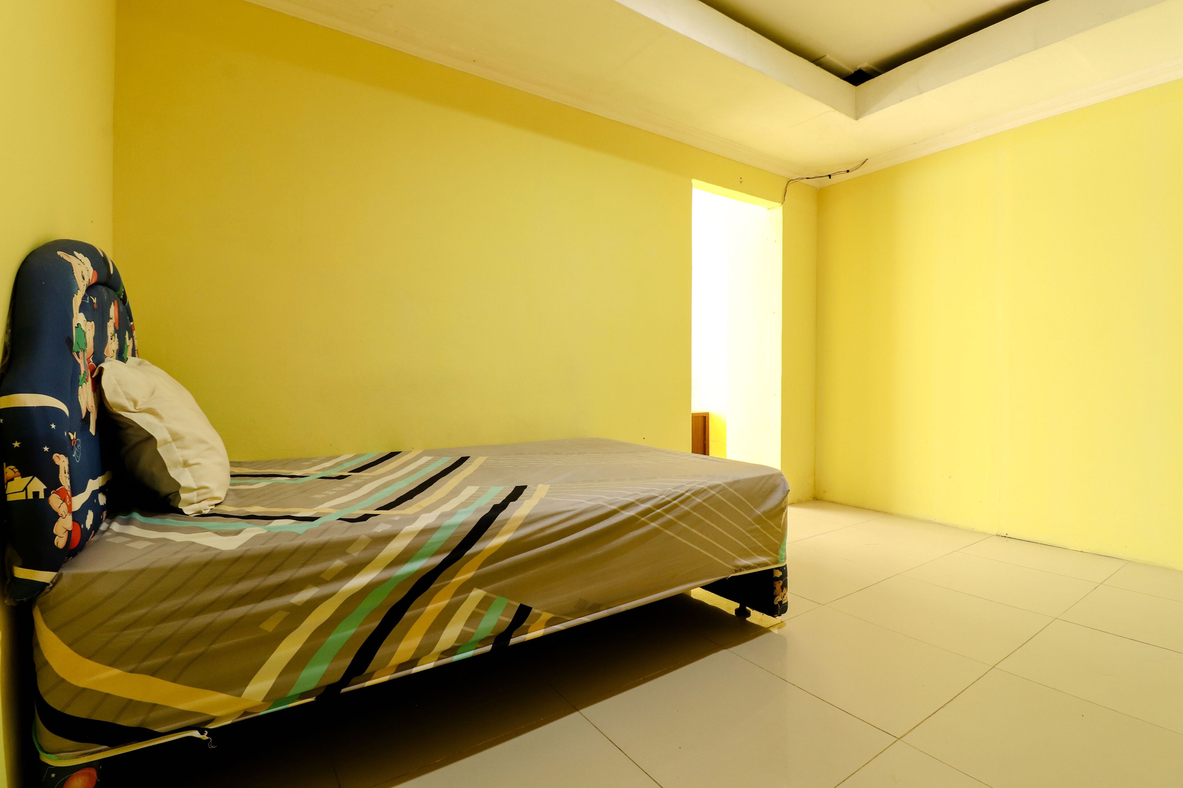 A room with a bed, a pillow, and a headboard.