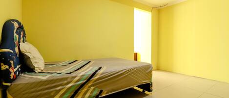 A room with a bed, a pillow, and a headboard.