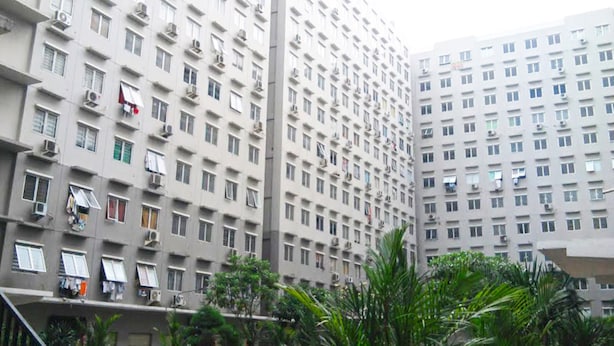 A high-rise residential building with multiple balconies, air conditioning units, and a uniform architectural style. - City Park Apartment by Anita (Jakarta)