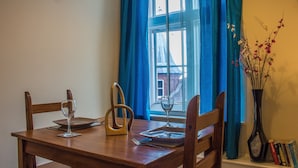 Una mesa de comedor preparada con una copa de vino, un plato y un tenedor.