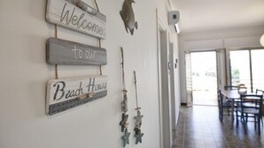 A hallway with a welcome sign, a fish decoration, and starfish ornaments.