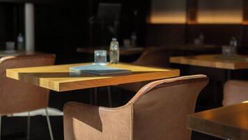 A restaurant interior with wooden tables and brown leather chairs.