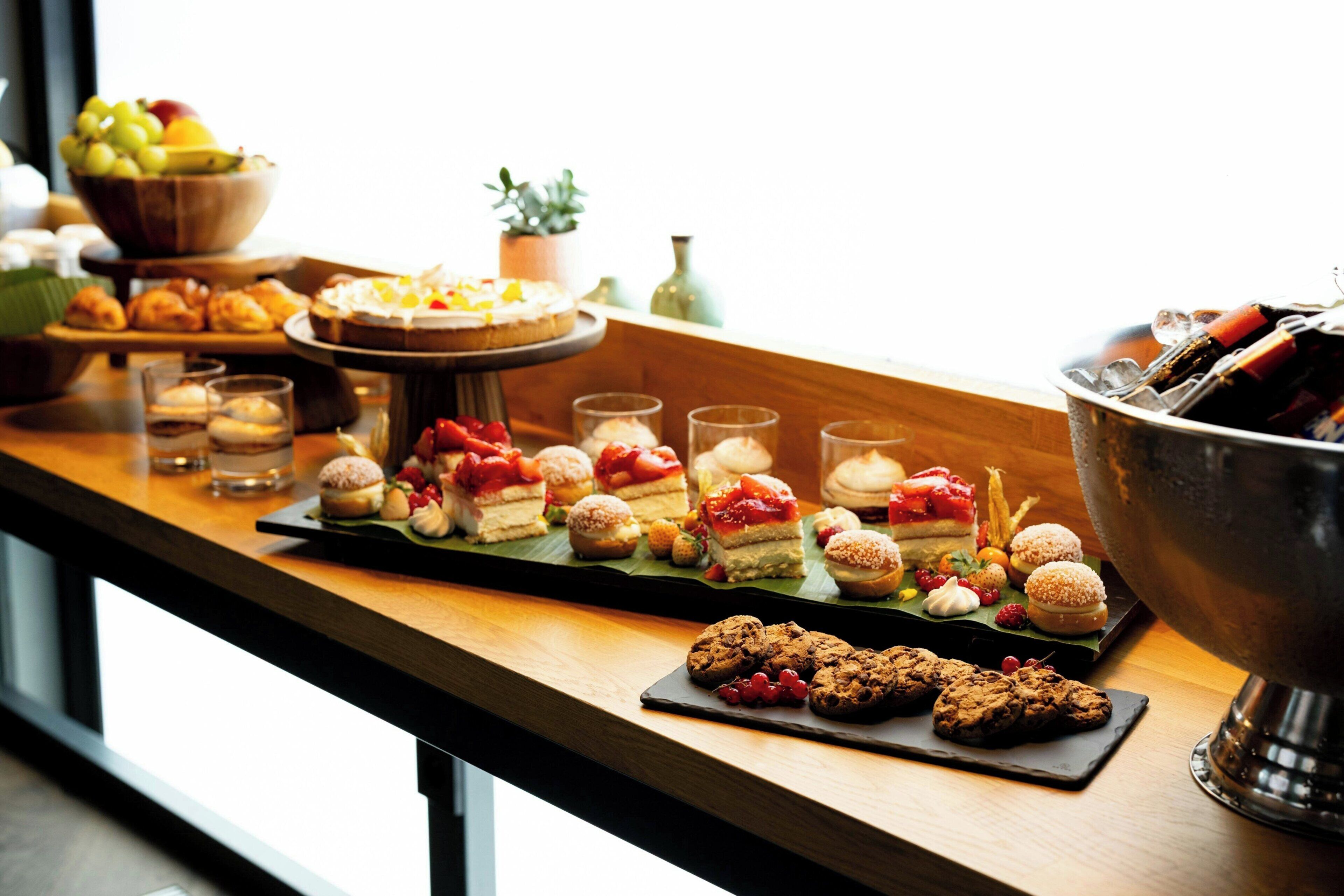 A buffet table with various desserts and snacks.